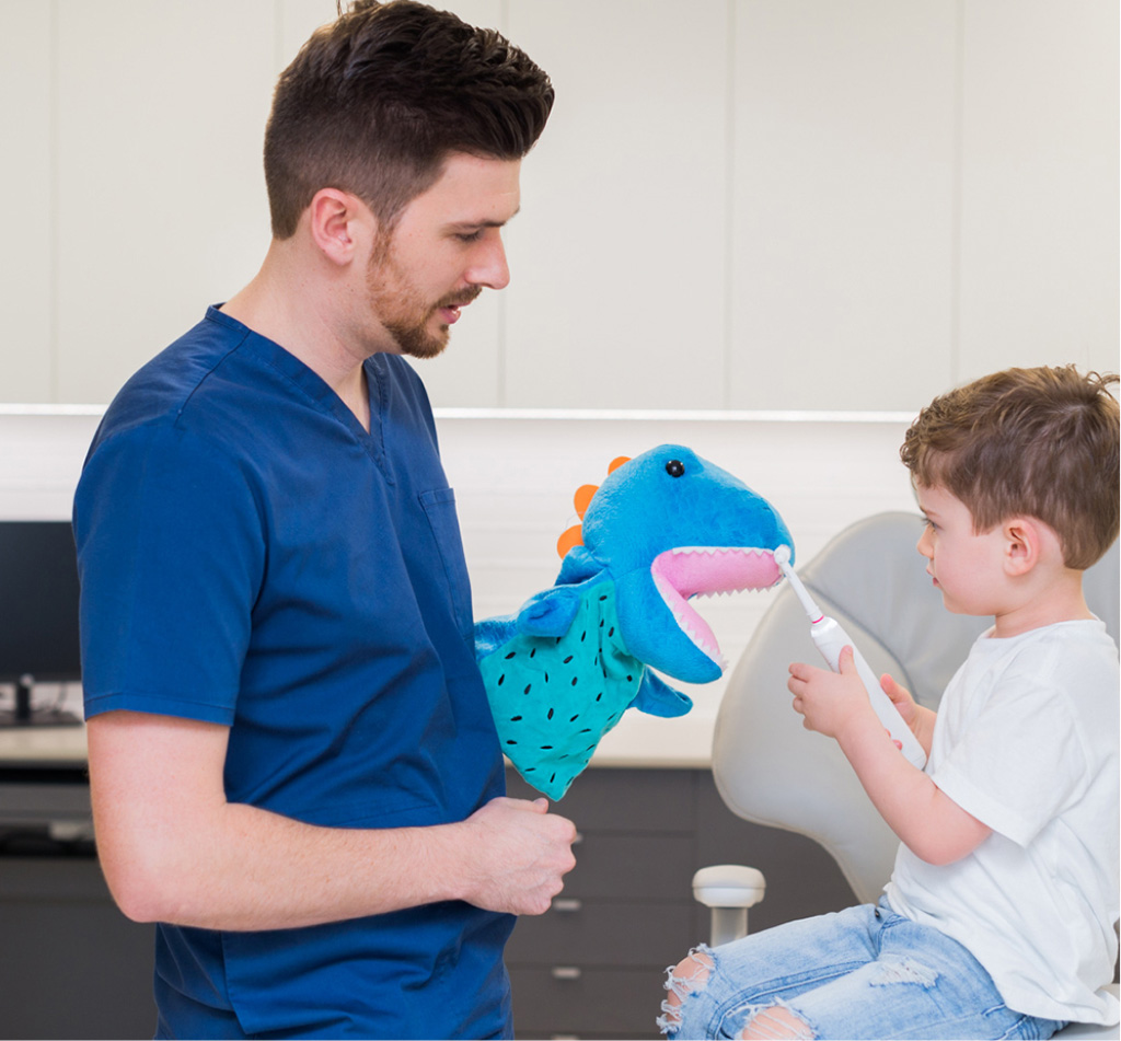a dentist showing dinosaur toy to a kid