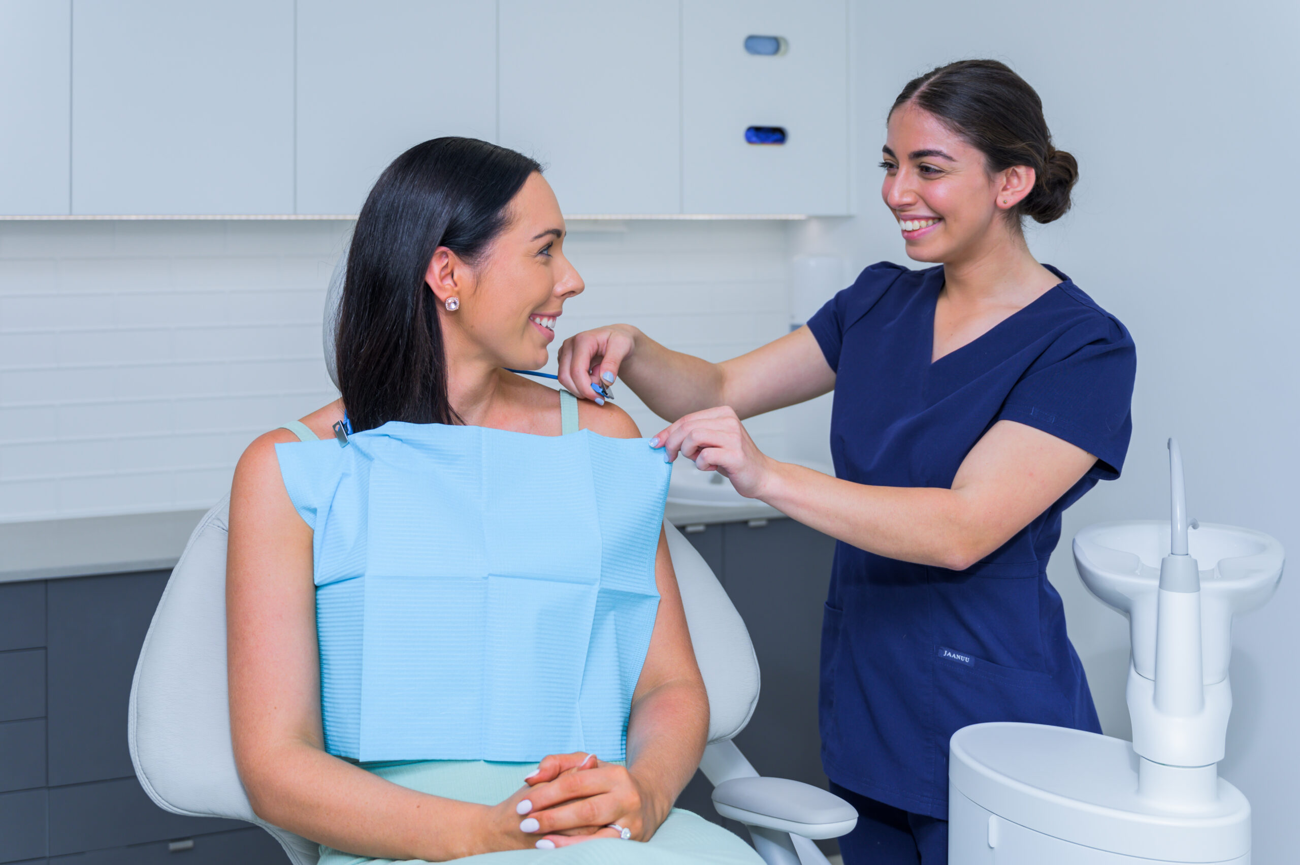a dentist putting blue cloth to her patient